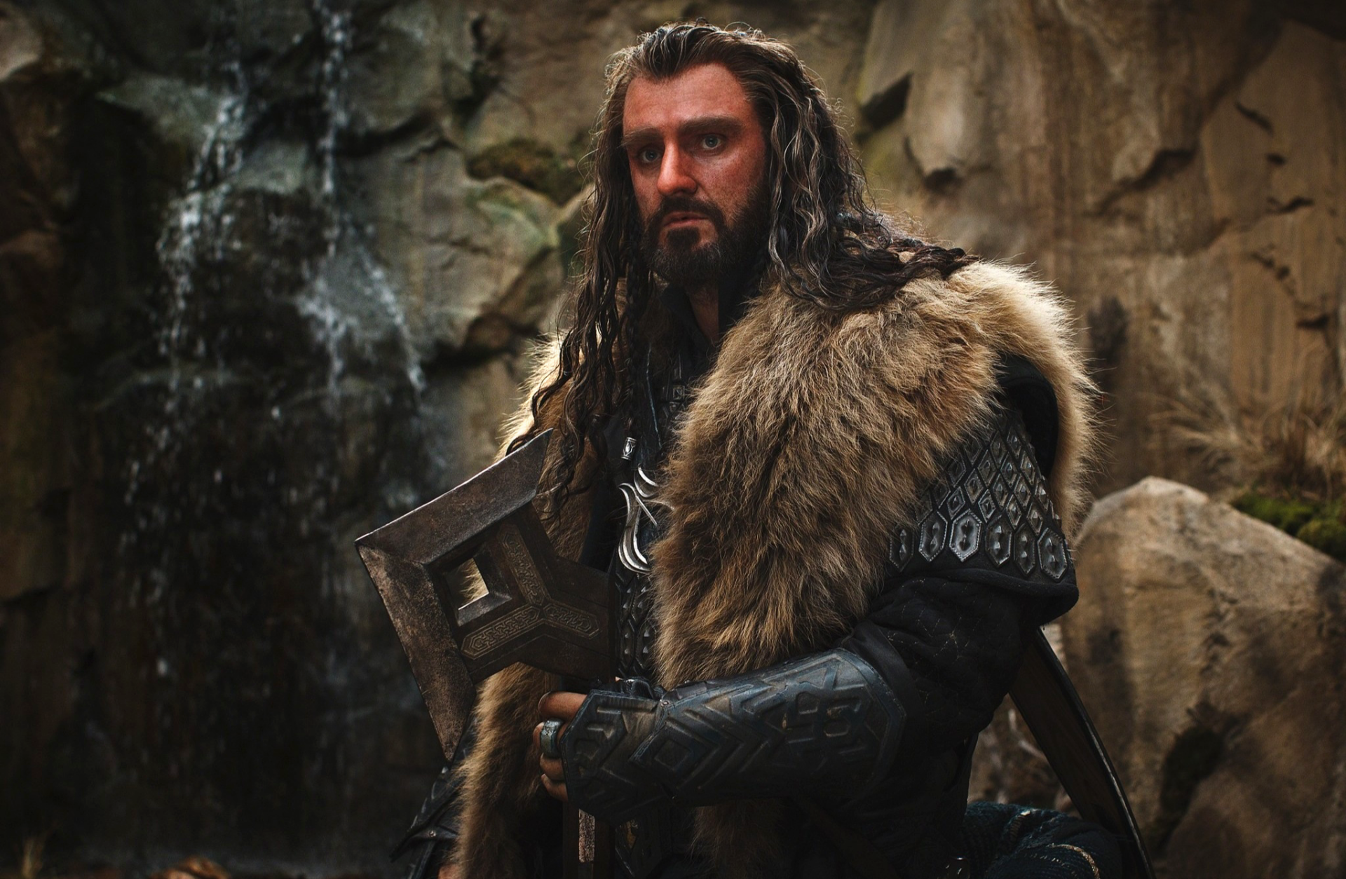 HD desktop wallpaper featuring a character from the movie The Hobbit: The Desolation of Smaug, dressed in fur and armor against a rocky backdrop.