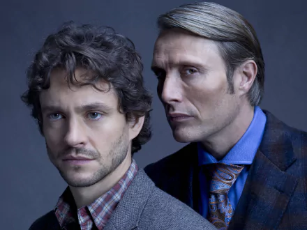 2K Quad HD desktop wallpaper for the TV show Hannibal: two men in formal attire posed closely in a moody blue studio portrait.