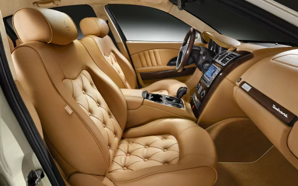 HD desktop wallpaper showing luxury Maserati Quattroporte car interior and dashboard with tan quilted leather seats, center console and steering wheel.
