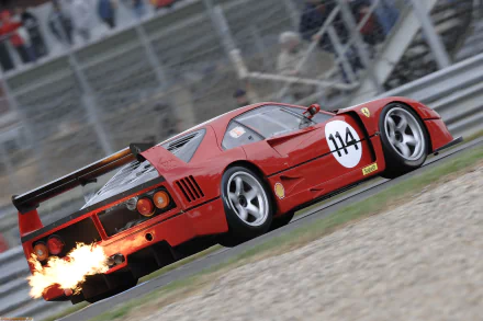 2K Quad HD PC desktop wallpaper: red Ferrari F40 race car (#114) spitting flames from its exhaust as it speeds around a racetrack.