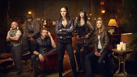 A captivating HD wallpaper featuring the cast of Lost Girl, showcasing the main characters in a dramatic setting filled with candles and rich decor.