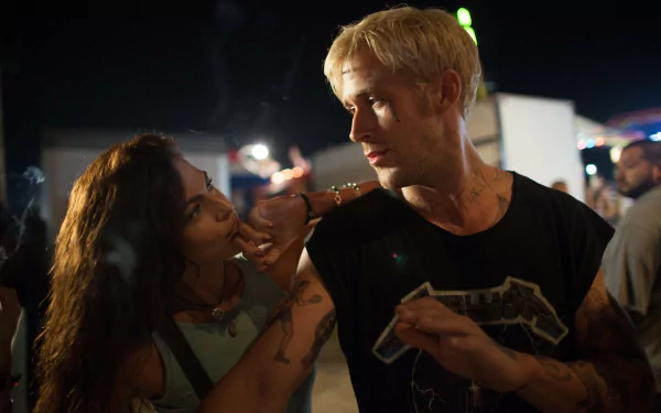 The Place Beyond the Pines movie still: a woman leans toward a blond man at a carnival, tense and intimate — 5K Ultra HD PC desktop wallpaper.