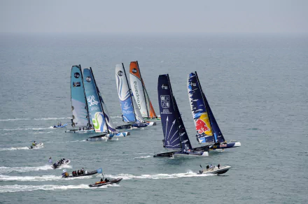 A fleet of colorful trimaran sailboats racing on calm water, captured in stunning 4K Ultra HD as a vibrant PC desktop wallpaper and background.