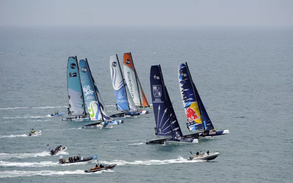 A fleet of colorful trimaran sailboats racing on calm water, captured in stunning 4K Ultra HD as a vibrant PC desktop wallpaper and background.