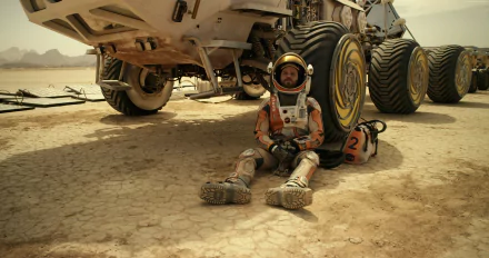 Matt Damon in his spacesuit from The Martian sits resting against a large rover on a barren, dusty landscape in this 4K Ultra HD movie desktop wallpaper.
