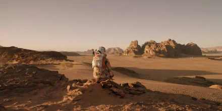 4K Ultra HD PC desktop wallpaper featuring an astronaut from the movie The Martian sitting on a rocky terrain under a clear sky.