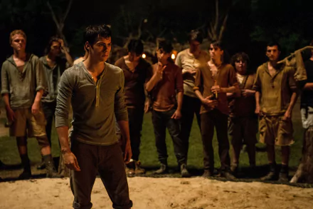 Dylan O'Brien in a tense scene from *The Maze Runner*, surrounded by fellow characters in a dimly lit setting, showcased in stunning 4K Ultra HD quality.