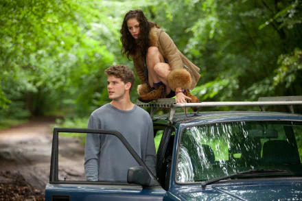 Kaya Scodelario and Jeremy Irvine in a scene from the movie Now Is Good, featured in a 4K Ultra HD PC desktop wallpaper with a lush green forest background.