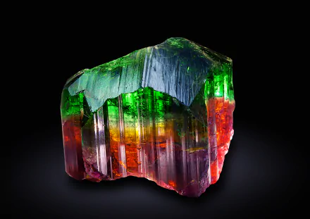 A vibrant mineral crystal displays stunning rainbow hues of green, red, and purple, set against a dark background, creating an eye-catching nature-inspired HD wallpaper.