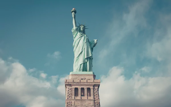 4K Ultra HD image of the man-made Statue of Liberty standing tall against a partly cloudy sky, captured as a PC desktop wallpaper and background.