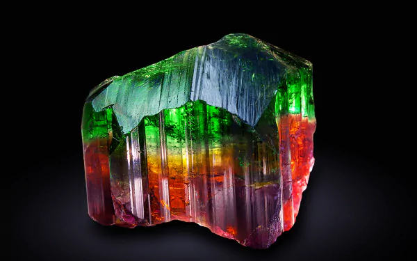 A vibrant mineral crystal displays stunning rainbow hues of green, red, and purple, set against a dark background, creating an eye-catching nature-inspired HD wallpaper.