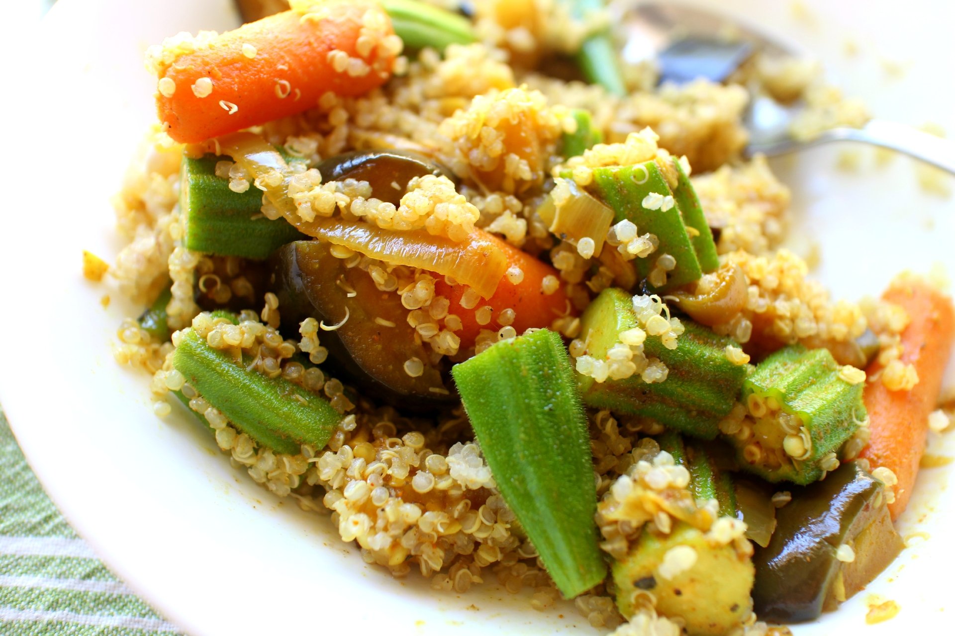 Close-up of a vibrant quinoa dish with fresh okra, carrots, and eggplant, captured in 4K Ultra HD as a PC desktop wallpaper and background.