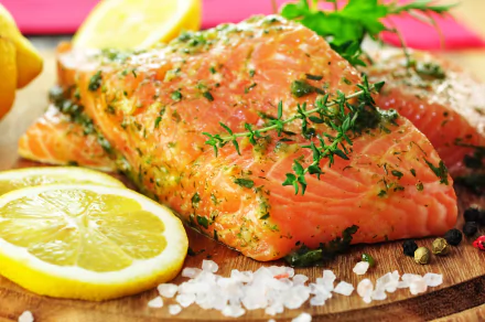 A vibrant HD wallpaper featuring fresh salmon fillets garnished with herbs, accompanied by lemon slices and sea salt, showcasing a delicious food aesthetic.