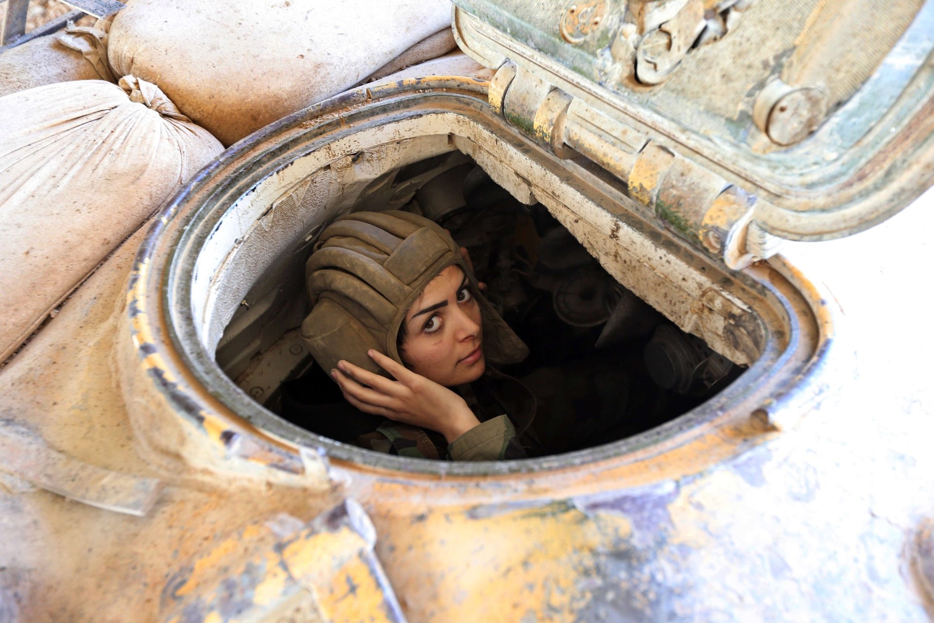 A soldier emerges from a tank, wearing a helmet and focused on the task at hand. The image serves as a striking 4K Ultra HD military-themed desktop wallpaper.