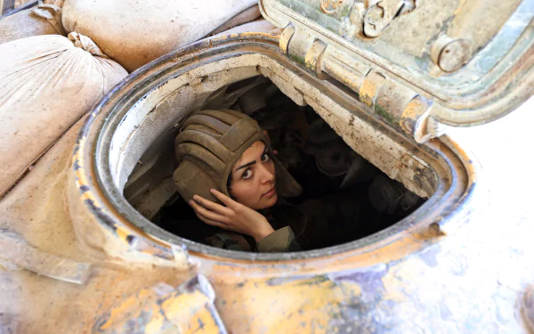A soldier emerges from a tank, wearing a helmet and focused on the task at hand. The image serves as a striking 4K Ultra HD military-themed desktop wallpaper.