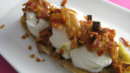 HD desktop wallpaper featuring a close-up of a banana split topped with whipped cream, caramel sauce, and crispy bacon bits.