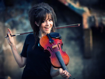 Brunette musician holds a violin, smiling joyfully. The image captures the vibrant energy of her performance, making it a captivating HD desktop wallpaper.