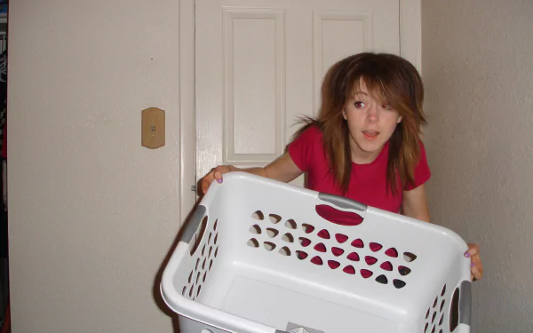 HD PC desktop wallpaper featuring Lindsey Stirling holding a white laundry basket against a plain indoor background, connected to music and her energetic style.