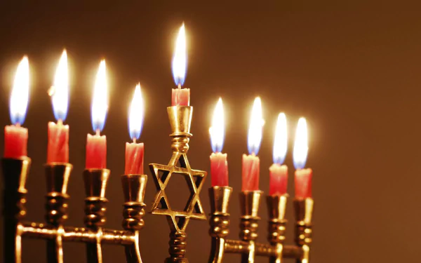 A beautifully illuminated menorah with red candles glowing warmly against a soft background, capturing the essence of Hanukkah in a stunning HD desktop wallpaper.