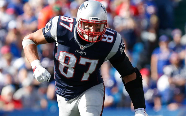 HD desktop wallpaper featuring a New England Patriots football player in action during a game, showcasing the team's colors and sports spirit.