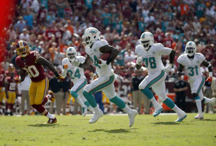 Miami Dolphins football players in white uniforms sprinting downfield during a game — sports action shot, HD PC desktop wallpaper and background.