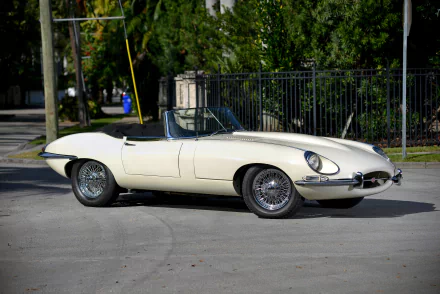 A white Jaguar E-Type classic car parked outdoors, showcased in a 4K Ultra HD PC desktop wallpaper and background.