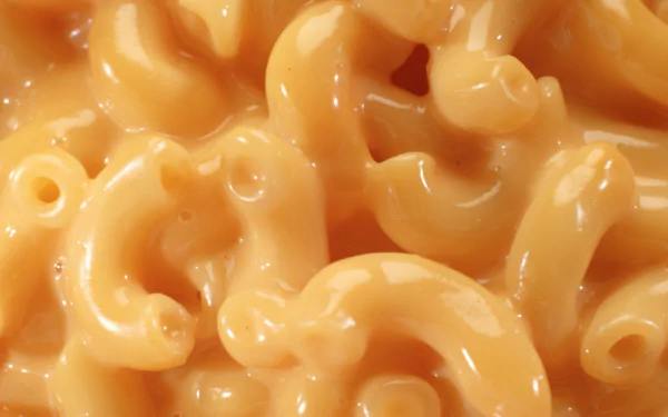 Close-up of creamy macaroni and cheese pasta, food image showing rich golden sauce coating elbow noodles, HD PC desktop wallpaper background