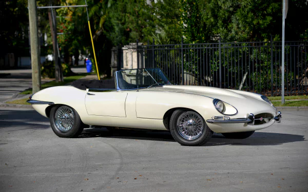 A white Jaguar E-Type classic car parked outdoors, showcased in a 4K Ultra HD PC desktop wallpaper and background.