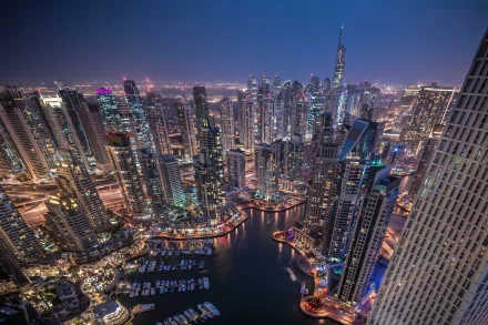 Nighttime cityscape of Dubai featuring illuminated skyscrapers and a marina, captured in high definition as a vibrant PC desktop wallpaper and background.