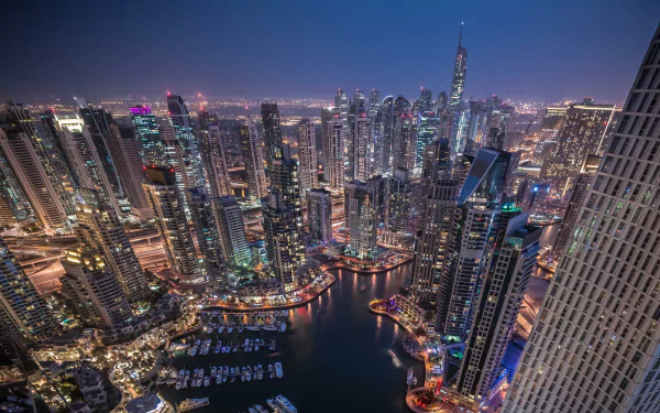Nighttime cityscape of Dubai featuring illuminated skyscrapers and a marina, captured in high definition as a vibrant PC desktop wallpaper and background.