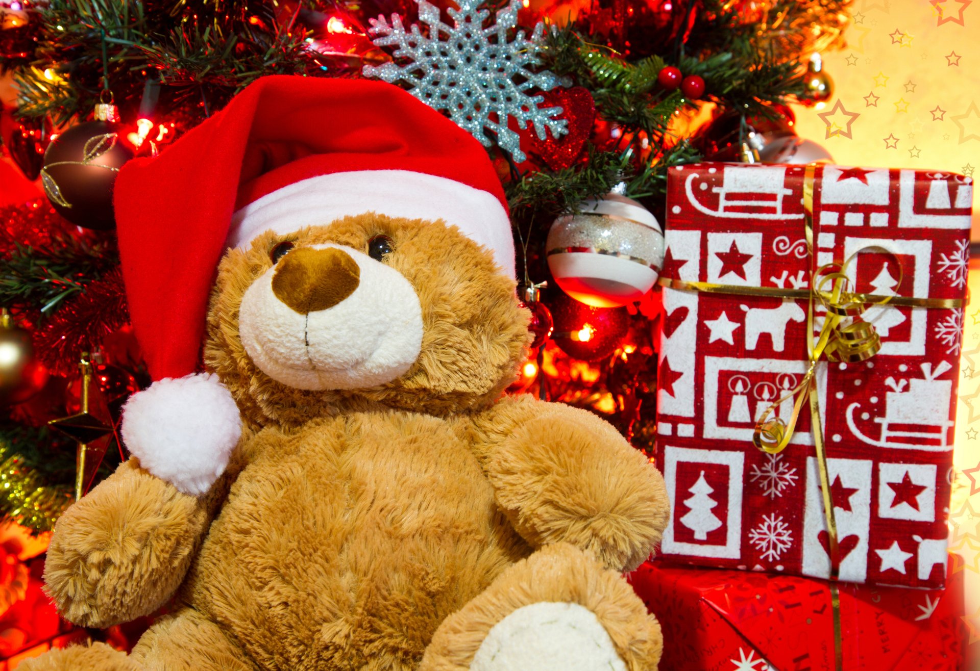 A cozy holiday scene featuring a teddy bear in a Santa hat, surrounded by colorful Christmas ornaments and beautifully wrapped gifts against a festive backdrop.