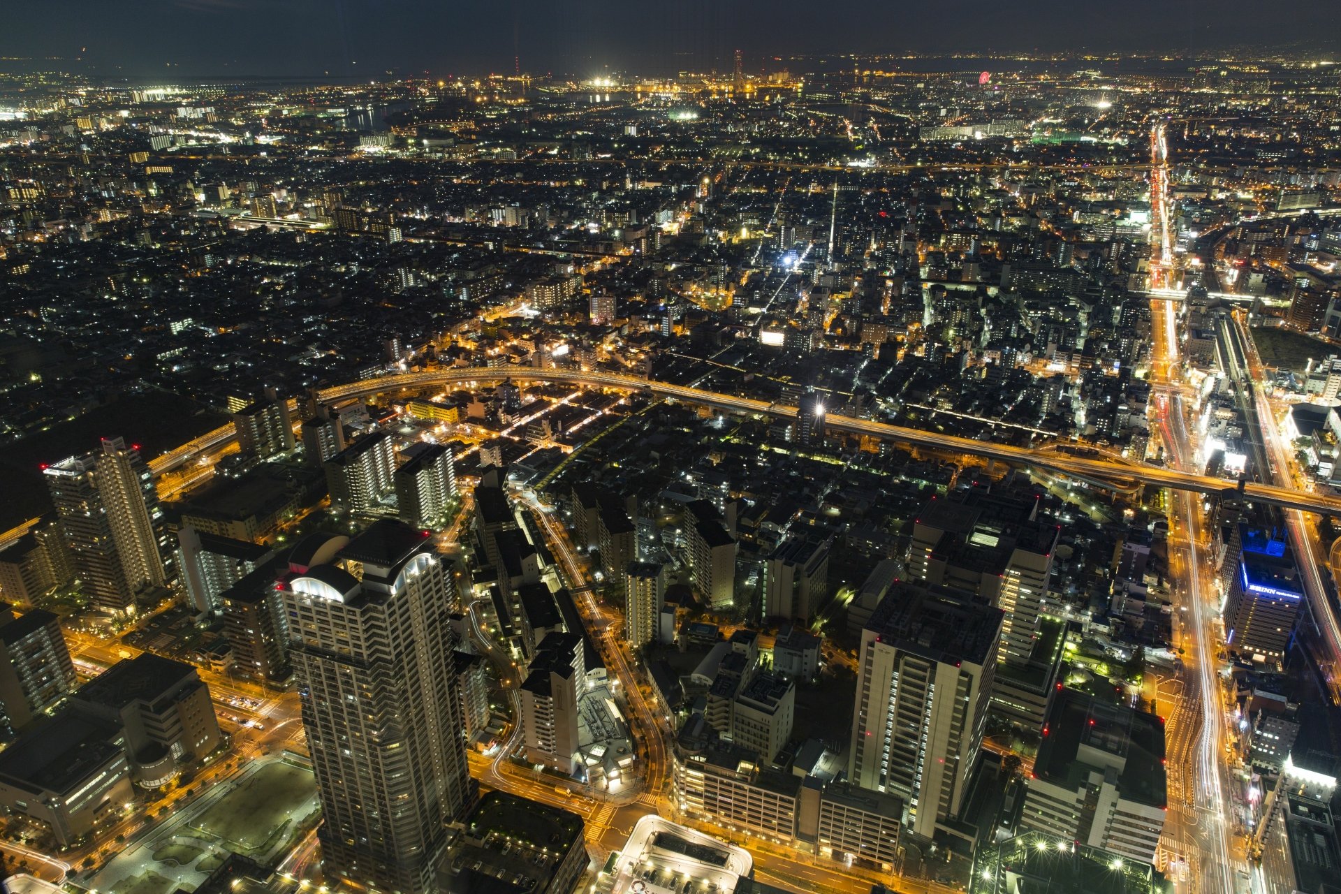 A vibrant 4K Ultra HD night view of Osaka, Japan, showcasing the city's sprawling man-made lights and urban landscape.