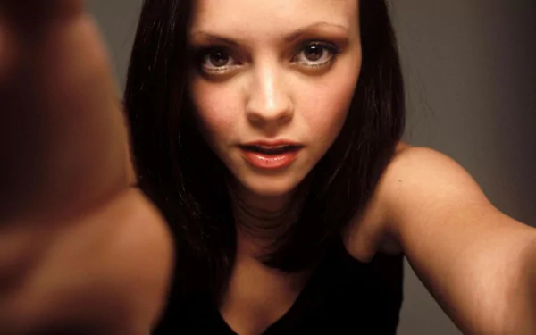 HD PC desktop wallpaper featuring a close-up of celebrity Christina Ricci with dark hair and intense eyes against a neutral background.