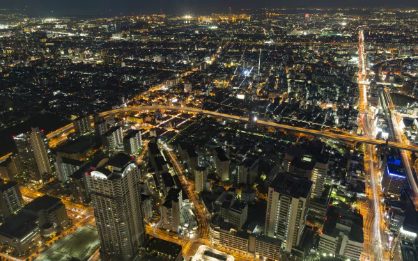 A vibrant 4K Ultra HD night view of Osaka, Japan, showcasing the city's sprawling man-made lights and urban landscape.