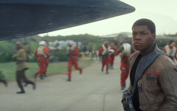 HD PC wallpaper featuring John Boyega as Finn from Star Wars Episode VII: The Force Awakens, set against a backdrop of pilots preparing for departure.