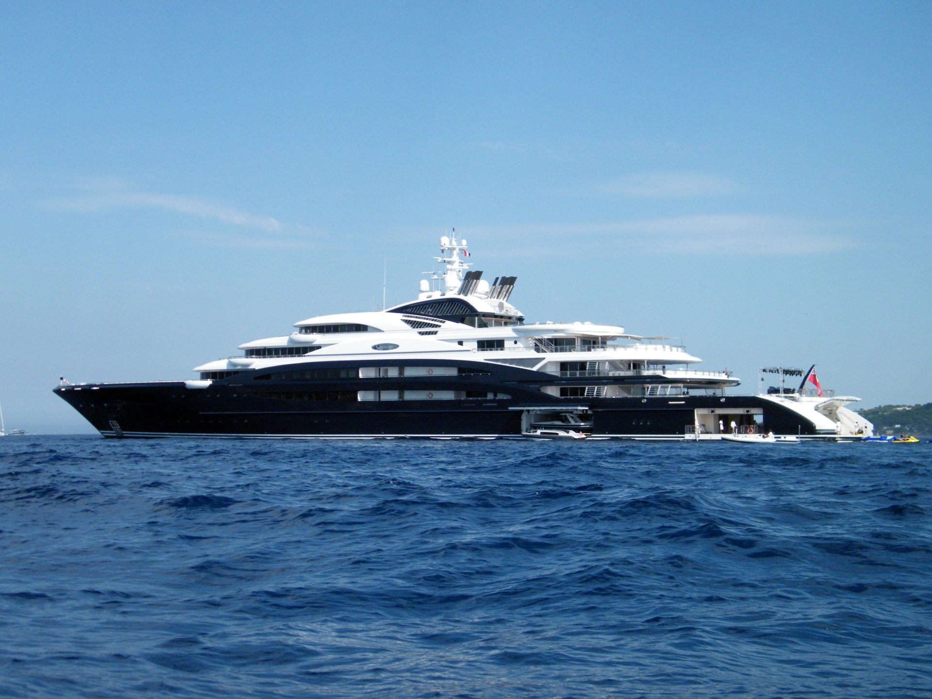 2K Quad HD PC desktop wallpaper: a luxury yacht vehicle gliding on deep blue sea beneath a clear sky.