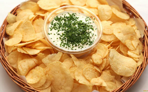 HD desktop wallpaper featuring a basket of golden potato chips surrounding a bowl of creamy dip topped with fresh herbs, highlighting food and potato themes.