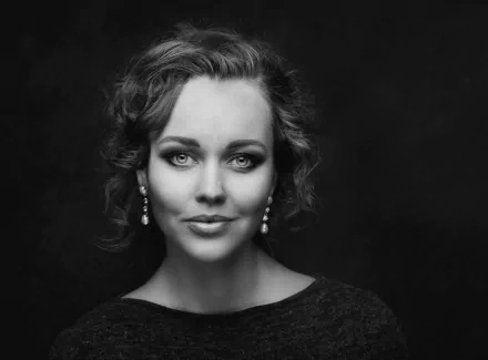 Black and white HD desktop wallpaper featuring a woman model with wavy hair wearing elegant dangling earrings against a dark background.