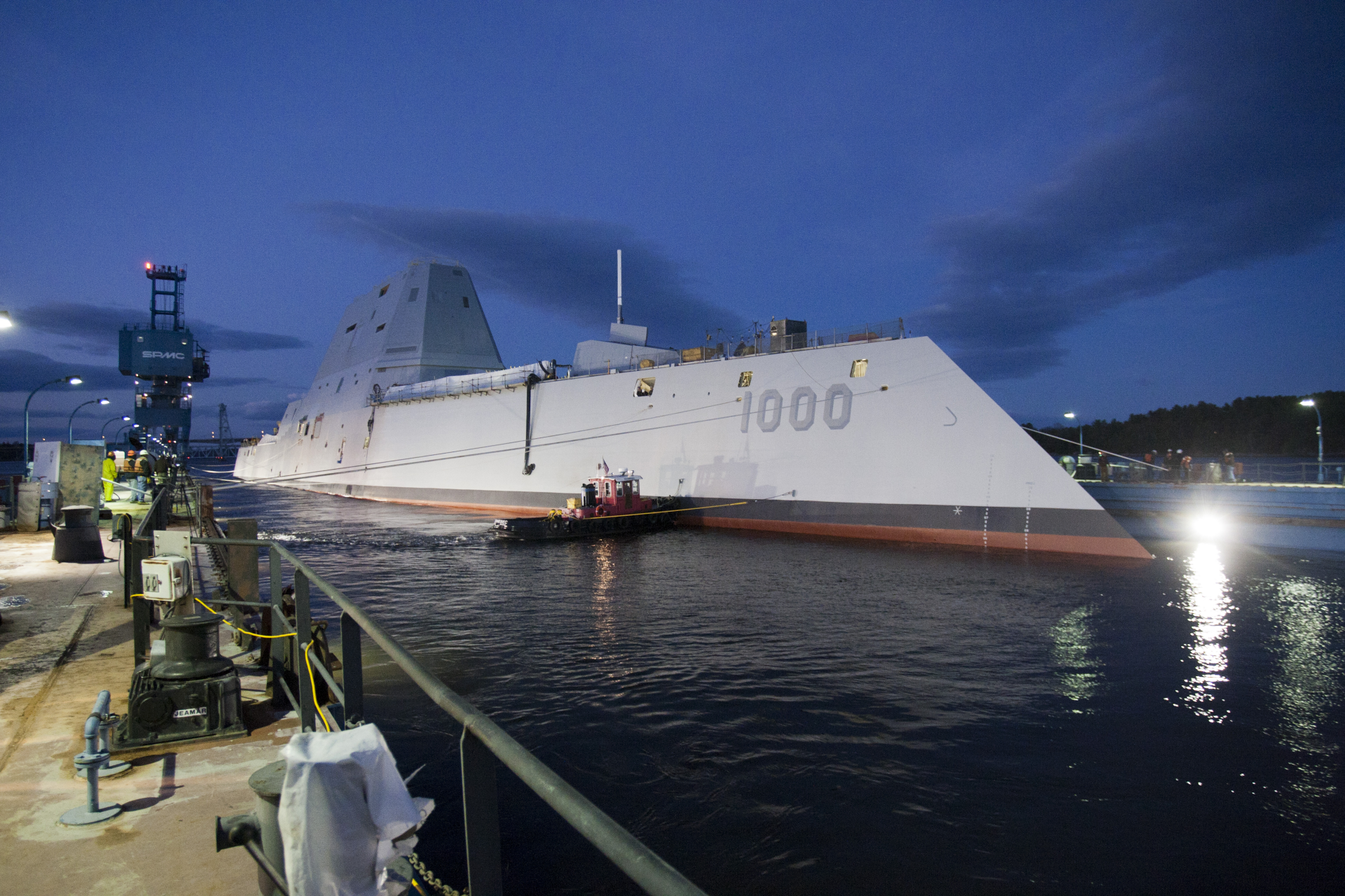 4K Ultra HD wallpaper featuring the USS Zumwalt (DDG-1000), a guided missile destroyer docked at night, showcasing its stealthy, angular military design.