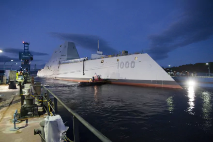 4K Ultra HD wallpaper featuring the USS Zumwalt (DDG-1000), a guided missile destroyer docked at night, showcasing its stealthy, angular military design.