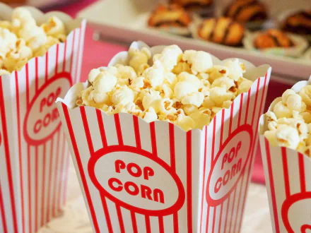 Close-up of striped popcorn containers filled with freshly popped popcorn, featured as an HD PC desktop wallpaper and background.