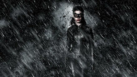 HD desktop wallpaper of Anne Hathaway as Selina Kyle/Catwoman from the movie The Dark Knight Rises, standing in the rain with a dark, moody background.