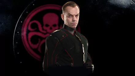 HD PC desktop wallpaper from Captain America: The First Avenger showing a stern HYDRA officer in a dark uniform posed before a glowing red HYDRA skull emblem.