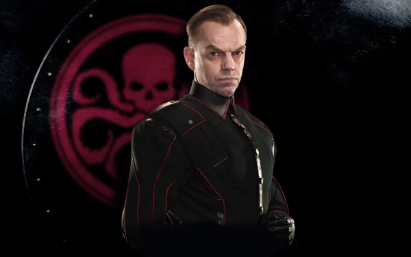 HD PC desktop wallpaper from Captain America: The First Avenger showing a stern HYDRA officer in a dark uniform posed before a glowing red HYDRA skull emblem.