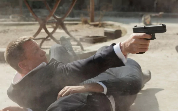HD PC desktop wallpaper: cinematic Skyfall movie scene — suited spy sprawled on the ground firing a handgun in a sunlit outdoor café.