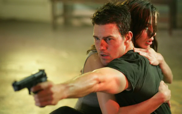 Tom Cruise and Michelle Monaghan in an intense scene from *Mission: Impossible III*, featuring action and suspense as Cruise aims a gun while holding Monaghan.
