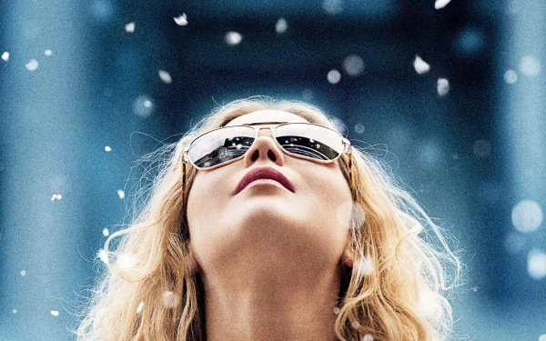 HD desktop wallpaper featuring Jennifer Lawrence in a close-up from the movie Joy (2015), wearing reflective sunglasses and looking upwards amidst falling snow.