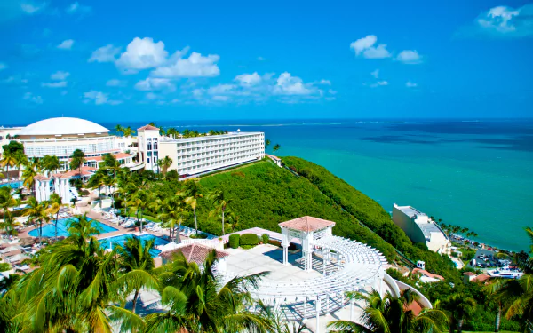 A vibrant 4K Ultra HD image of a tropical Puerto Rico resort featuring a hotel building overlooking the beach and horizon under a bright blue sky.