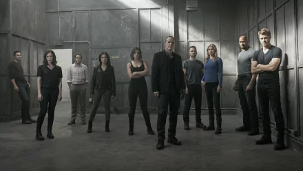 HD desktop wallpaper featuring the main cast of the TV show Agents of S.H.I.E.L.D. standing confidently in an industrial, dimly lit setting.