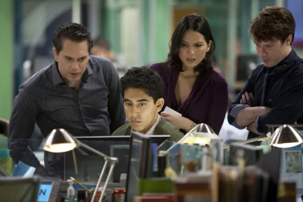HD desktop wallpaper of 'The Newsroom' (2012) showing four characters intensely focused on work at their newsroom desks.